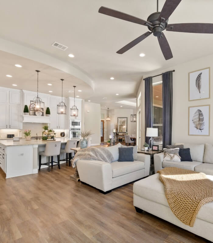 Open living room and kitchen with white cabinets and neutral furnishings
